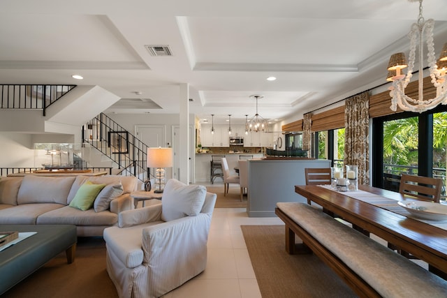 living room with light tile patterned floors, a raised ceiling, and a chandelier