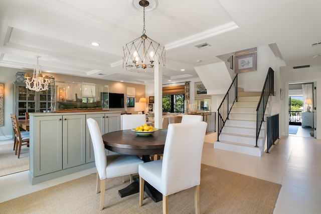 tiled dining area with ornamental molding, a tray ceiling, and a chandelier