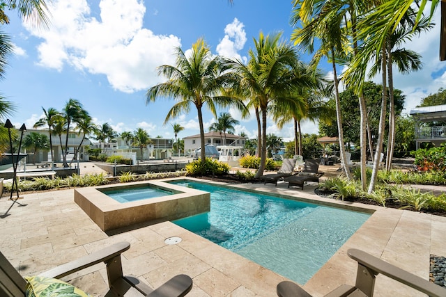 view of swimming pool featuring a patio area and an in ground hot tub