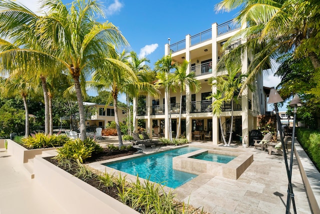 view of swimming pool with a patio and an in ground hot tub