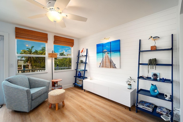 sitting room with ceiling fan and light hardwood / wood-style flooring