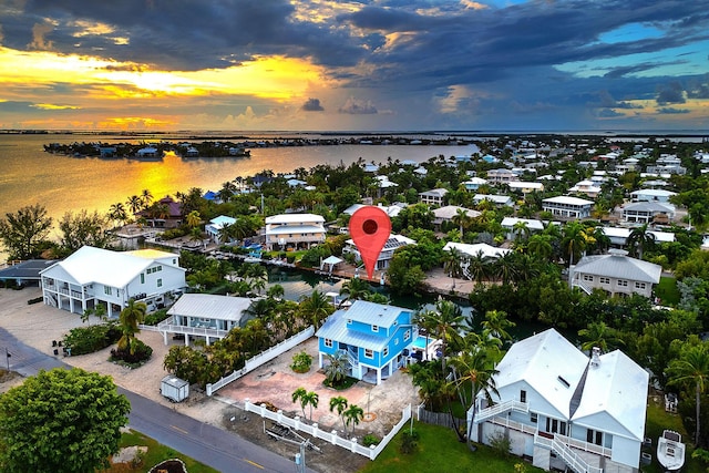 aerial view at dusk featuring a water view