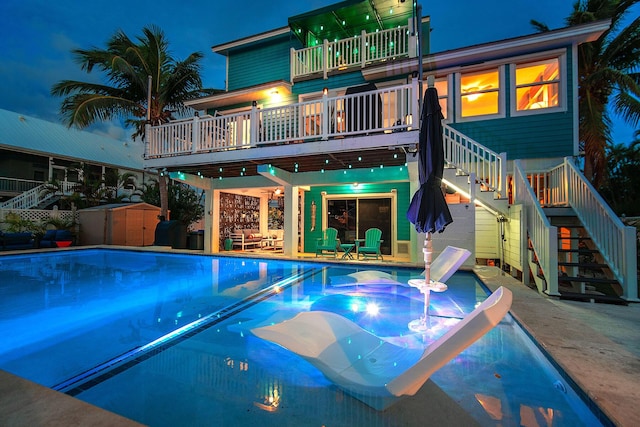 pool at night with a shed and a patio area