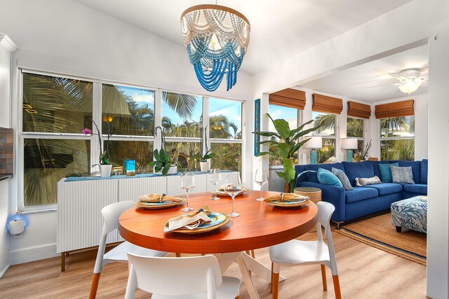 sunroom with ceiling fan with notable chandelier and radiator heating unit