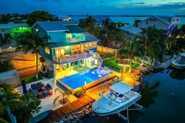 exterior space featuring a dock, a patio area, and a water view