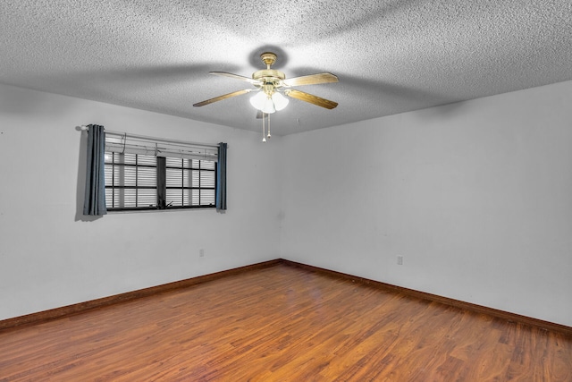 unfurnished room with a ceiling fan, a textured ceiling, baseboards, and wood finished floors