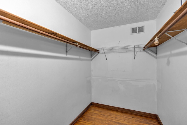 walk in closet with wood finished floors and visible vents