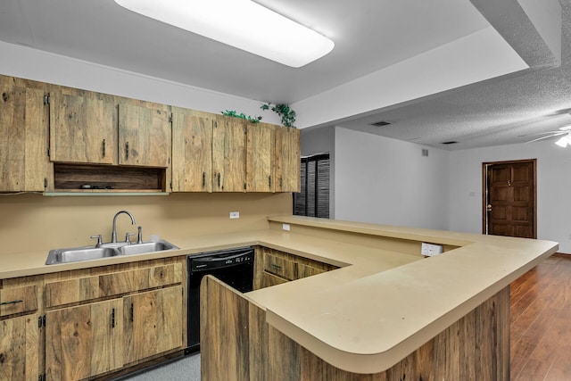 kitchen featuring black dishwasher, light countertops, a peninsula, and a sink