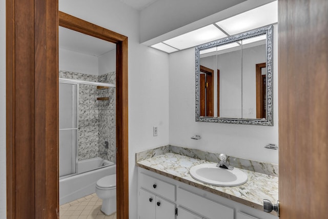 bathroom featuring toilet, bath / shower combo with glass door, and vanity