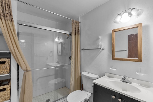 full bath featuring a textured wall, toilet, a shower stall, and vanity