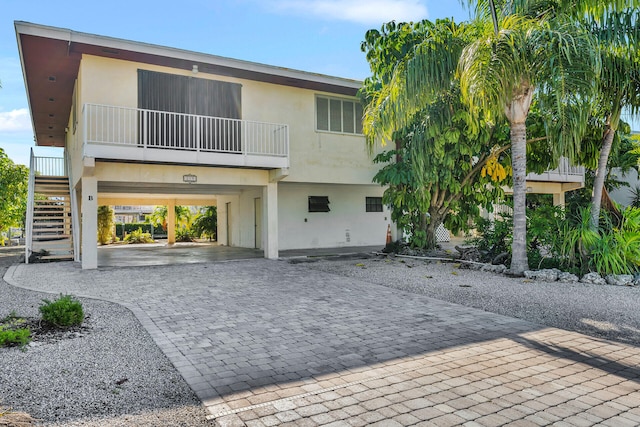 view of front of home featuring a carport, decorative driveway, and stucco siding