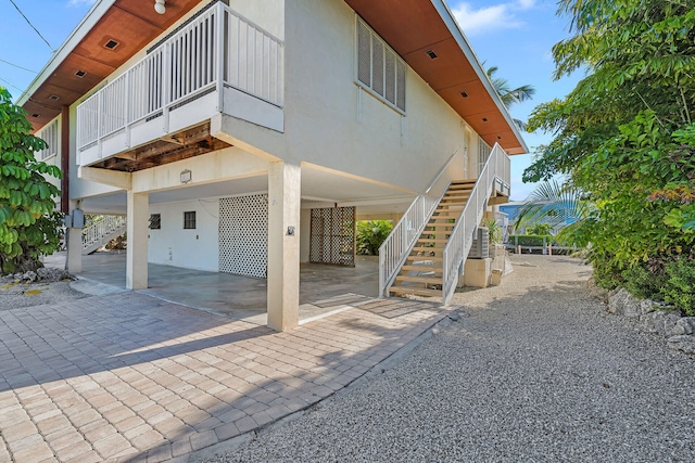 exterior space with stairway and stucco siding