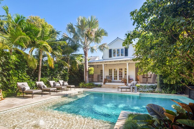 1109 Fleming St, Key West, FL 33040 - rear view of house featuring french doors, a patio area, an outdoor pool, and metal roof