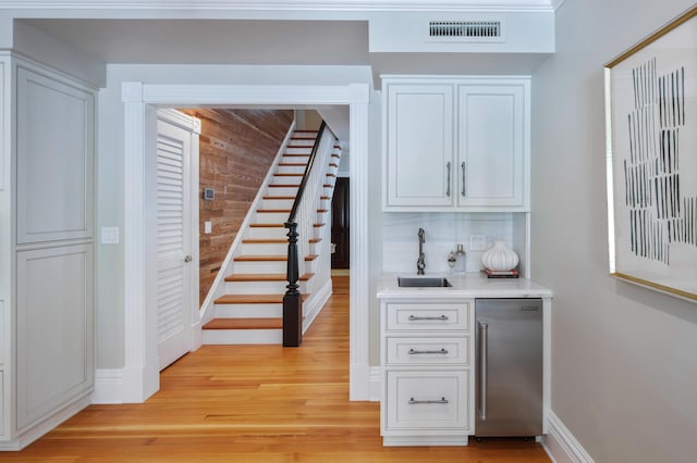 1109 Fleming St, Key West, FL 33040 - indoor bar featuring light wood finished floors, stairs, dishwasher, baseboards, and wooden walls