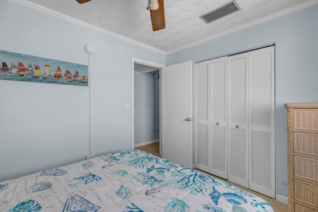 bedroom with visible vents, baseboards, a ceiling fan, ornamental molding, and a closet