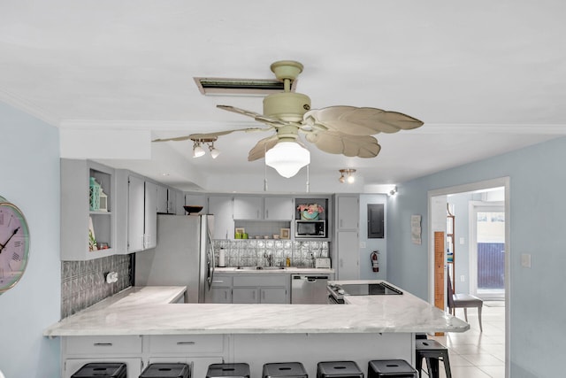 kitchen with a peninsula, stainless steel appliances, a sink, decorative backsplash, and open shelves