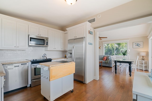 kitchen with white cabinetry, tasteful backsplash, dark hardwood / wood-style floors, a kitchen island, and stainless steel appliances