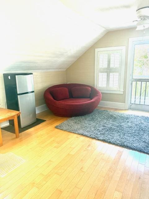 additional living space with vaulted ceiling, wood finished floors, baseboards, and ceiling fan