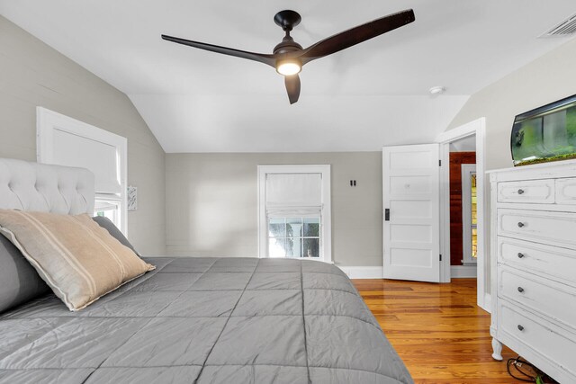 bedroom with vaulted ceiling, wood finished floors, and a ceiling fan