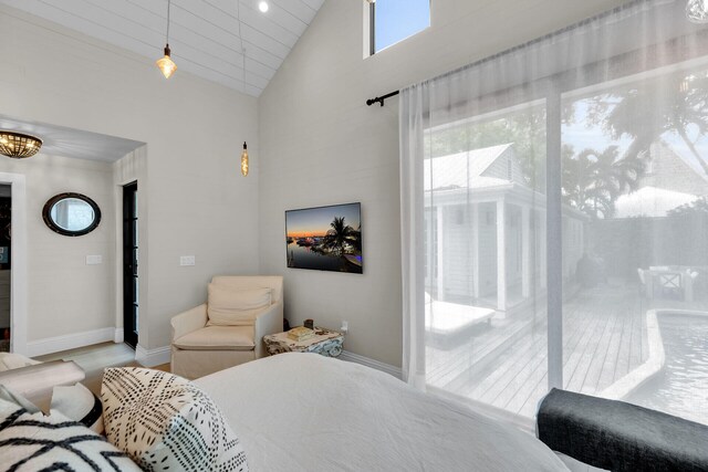 bedroom featuring baseboards, high vaulted ceiling, a chandelier, and wood finished floors