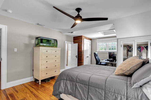 bedroom with light wood-type flooring, ceiling fan, and baseboards