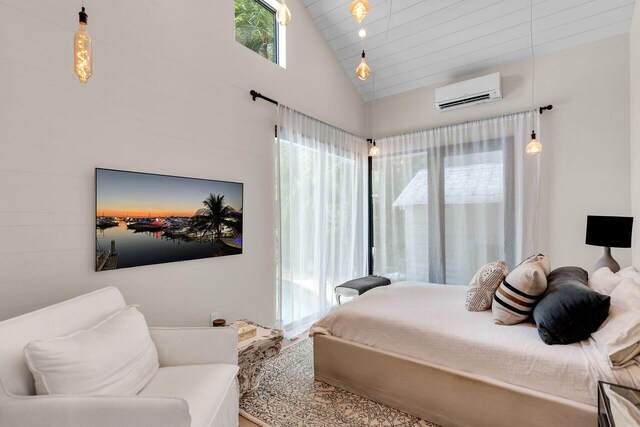 bedroom with a wall unit AC and high vaulted ceiling