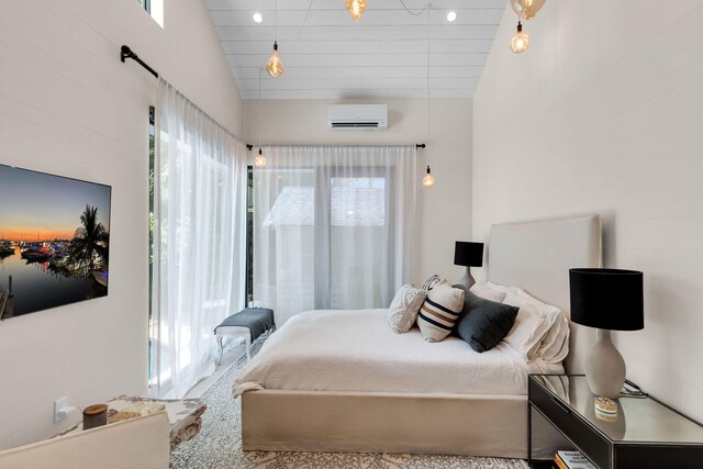 bedroom with a wall mounted AC, multiple windows, and vaulted ceiling
