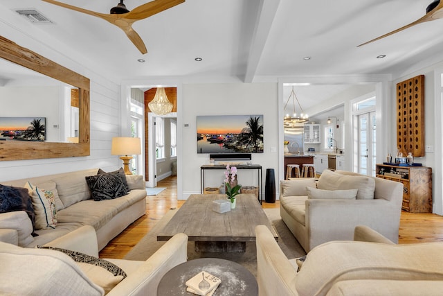 living area featuring light wood finished floors, a ceiling fan, beam ceiling, a chandelier, and recessed lighting