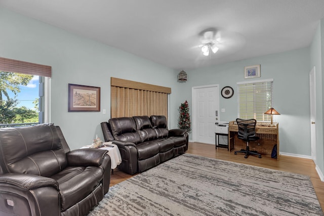 living room featuring ceiling fan, wood finished floors, and baseboards