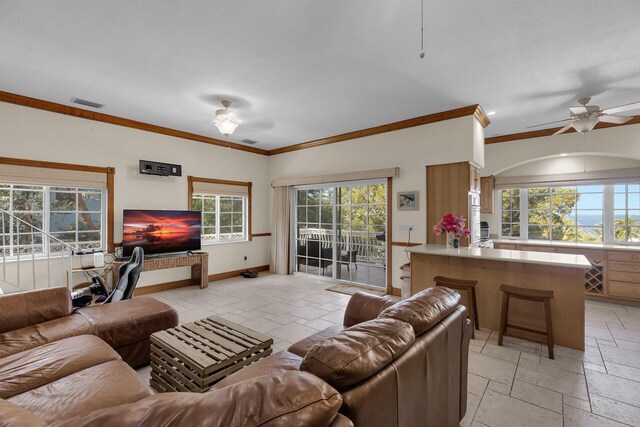 living room with ornamental molding and ceiling fan