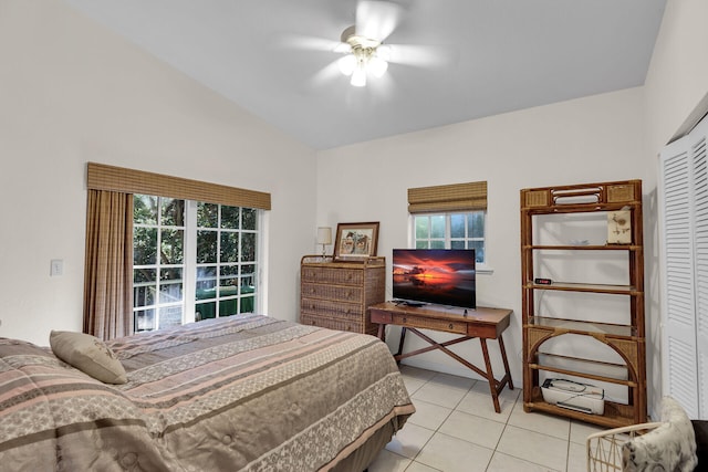 tiled bedroom featuring ceiling fan, a closet, and multiple windows