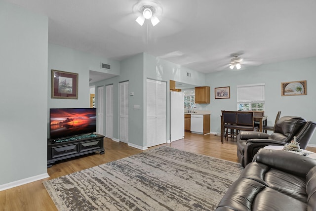 living room featuring ceiling fan and light wood-type flooring