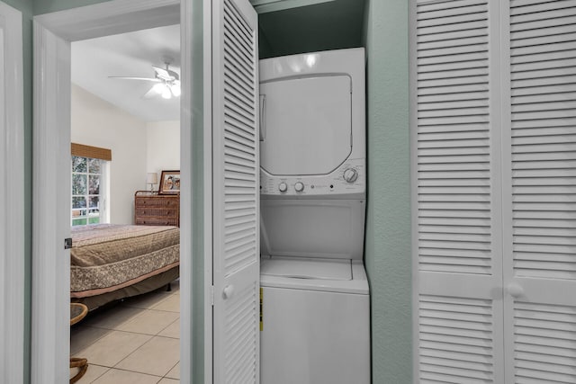 washroom featuring ceiling fan, stacked washing maching and dryer, and light tile patterned floors