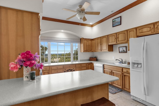 kitchen with ornamental molding, white appliances, a peninsula, light countertops, and a sink