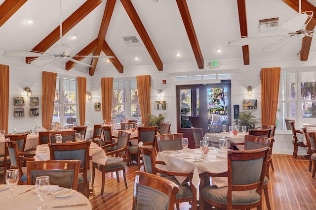 dining room with wood-type flooring, plenty of natural light, vaulted ceiling with beams, and ceiling fan