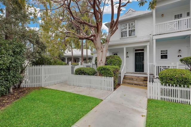 view of front of home featuring a balcony and a front lawn