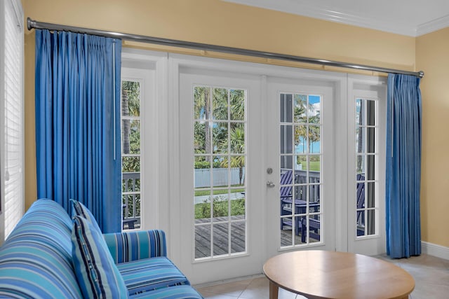 doorway featuring a healthy amount of sunlight, ornamental molding, and light tile patterned floors