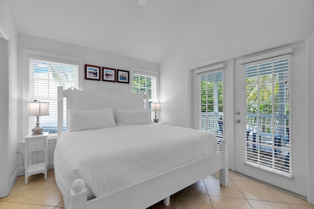 tiled bedroom featuring lofted ceiling and access to outside