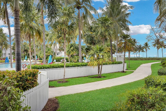 view of community featuring a pool and a yard