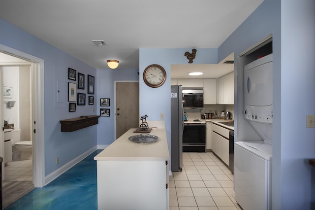 kitchen featuring range with electric stovetop, light tile patterned flooring, stainless steel fridge, white cabinets, and stacked washer and clothes dryer