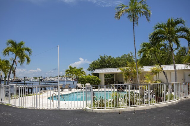 view of pool featuring a patio and a water view