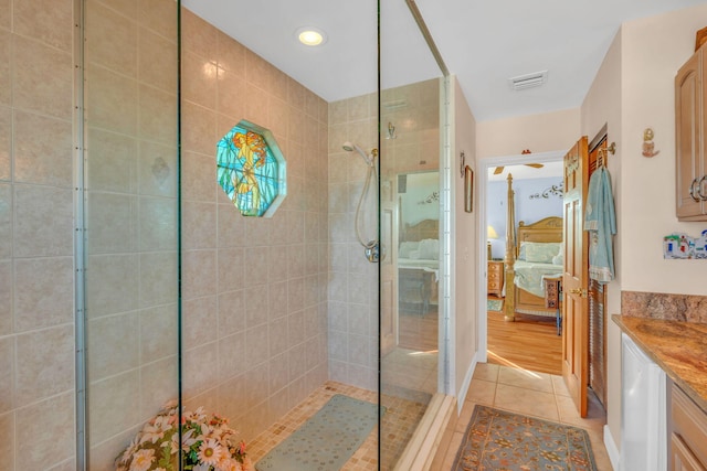 bathroom featuring vanity, a tile shower, and tile patterned floors