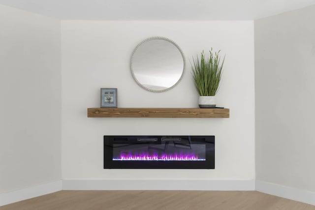 82260 Overseas Hwy, Islamorada, FL 33036 - detailed view of a glass covered fireplace, wood finished floors, and baseboards