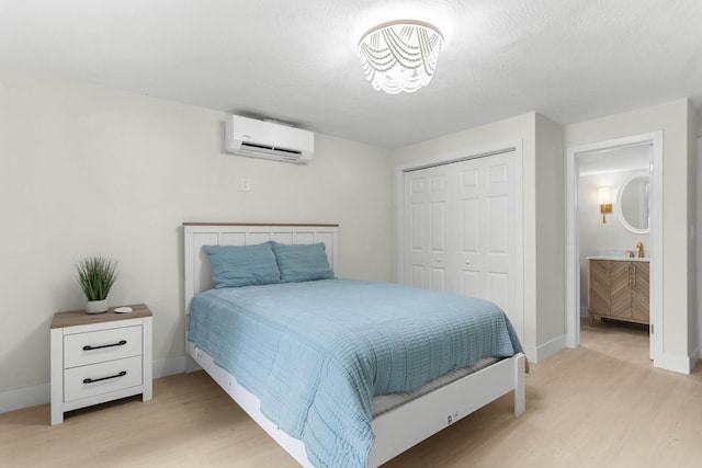 82260 Overseas Hwy, Islamorada, FL 33036 - bedroom featuring an AC wall unit, light wood-type flooring, a closet, and baseboards