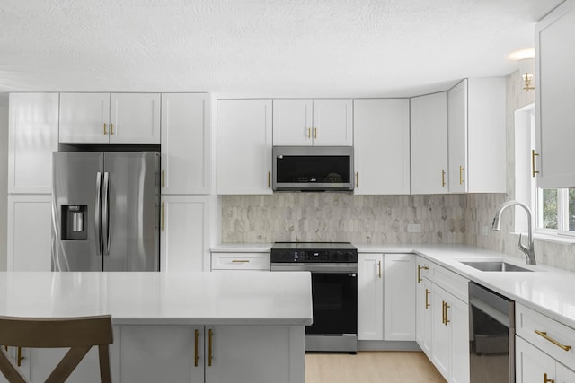 82260 Overseas Hwy, Islamorada, FL 33036 - kitchen with stainless steel appliances, a sink, light countertops, white cabinets, and decorative backsplash