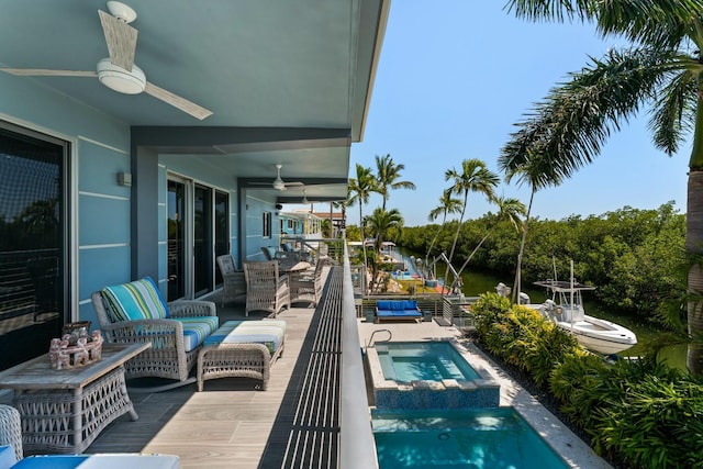 pool with a water view, a ceiling fan, and an in ground hot tub
