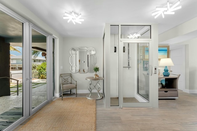 interior space featuring baseboards, wood finished floors, and a notable chandelier