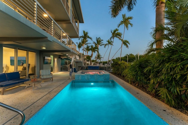 view of swimming pool with a patio and a pool with connected hot tub