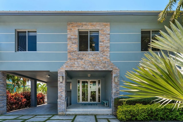 exterior space with a carport and stone siding