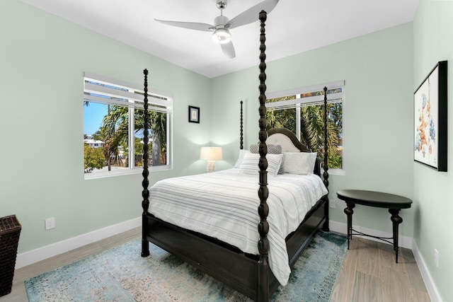 bedroom featuring light wood-style floors, baseboards, and multiple windows